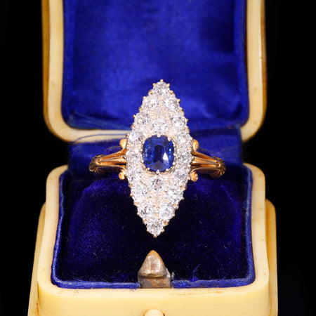 Victorian sapphire and old cut diamond navette cluster ring in yellow gold, with a central oval blue sapphire surrounded by old cut diamonds in a marquise-shaped bezel