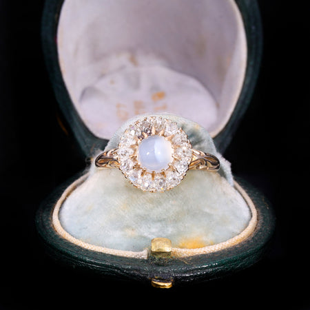 Victorian moonstone and old cut diamond cluster ring in gold, featuring a central cabochon moonstone surrounded by old cut diamonds in claw settings