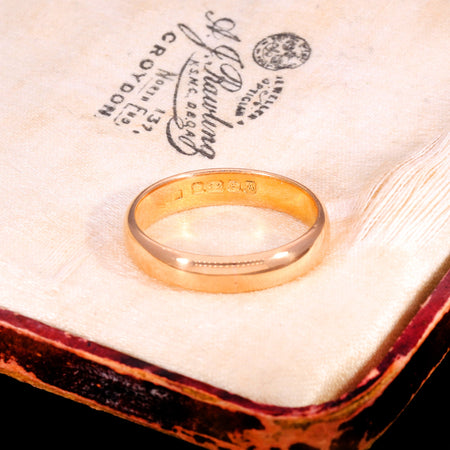 Victorian 22ct gold wedding ring from 1849 showing hallmarks stamped inside the band, displayed on an antique jeweller's box