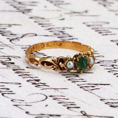 Victorian ring in 15ct gold with emerald and seed pearls, circa 1868, showing hallmark stamps clearly visible on the shank of the band