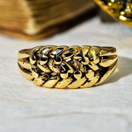 Victorian keeper ring in 18ct yellow gold, dated 1899, with carved interlocking leaf pattern widening at the centre and tapering to plain gold shoulders