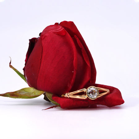 Victorian diamond solitaire ring in 22ct yellow gold with open-back collet setting, dated 1873, showing a single old cut diamond in a round bezel mount